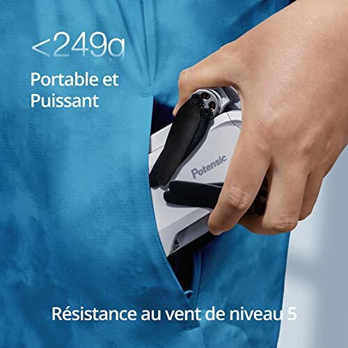 Hand placing a compact drone into a pocket, labeled 'Portable et Puissant' and 'RÃÂÃÂÃÂÃÂÃÂÃÂÃÂÃÂÃÂÃÂÃÂÃÂÃÂÃÂÃÂÃÂ©sistance au vent de niveau 5'.